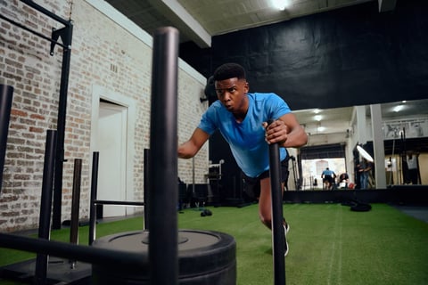 African American man pushing the sled in the gym