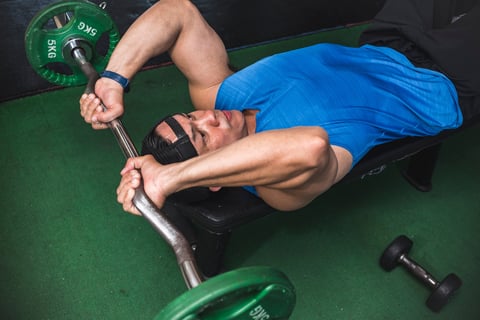 Athletic male doing lying tricep extensions