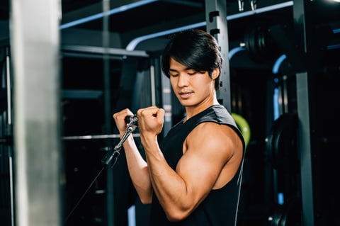 Adult bodybuilder doing cable triceps pull-up with heavy weight