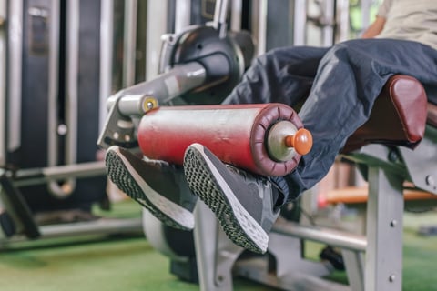 Close up of male leg exercise in gym training quads