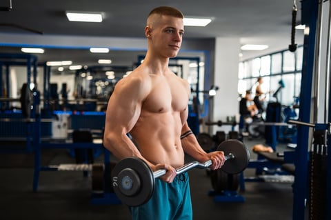 Bodybuilder training biceps with barbell