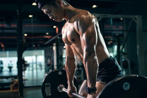 Man performing deadlift exercise with barbell in gym