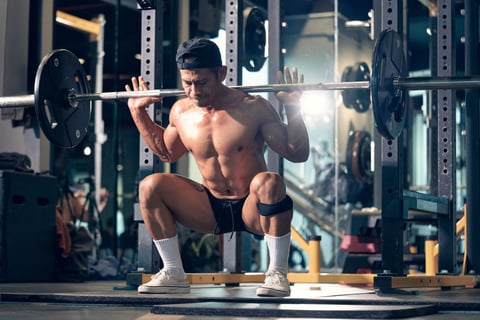 Sporty man bodybuilder exercising deadlift with barbell on cross training in a gym