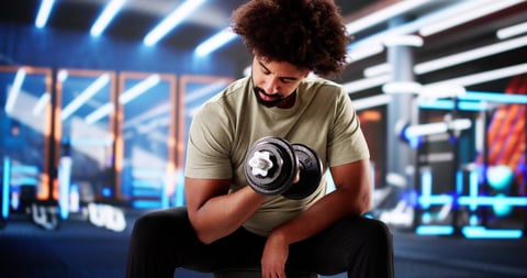 Trainer encouraging man lifting heavy weights