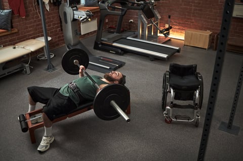 Person in starting position on bench press with bar above chest