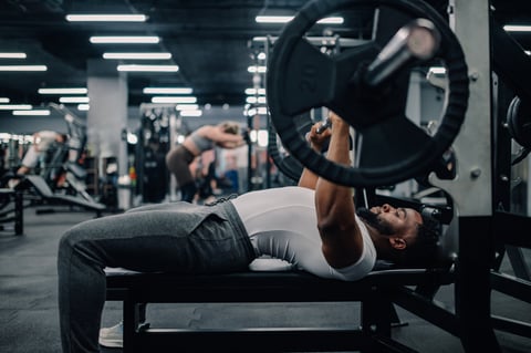Athlete lowering bar to chest during bench press movement