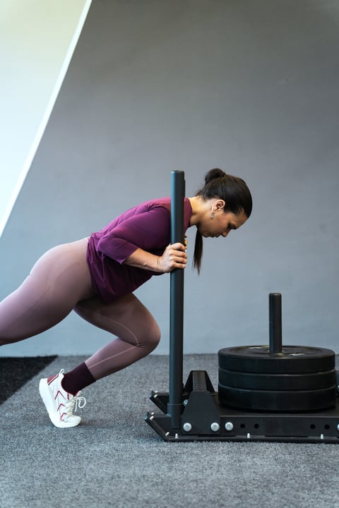 Latin american woman engaging in intense sled push exercise