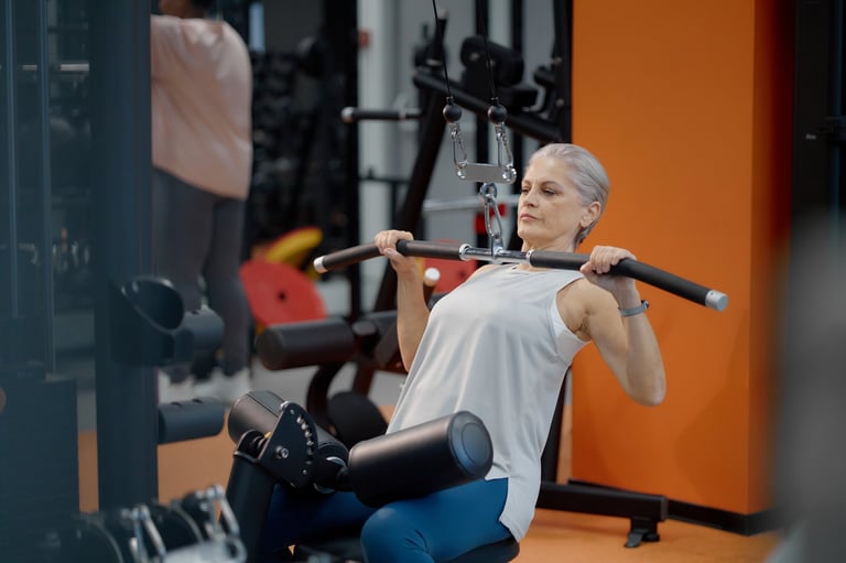 Senior Caucasian woman exercising on lat pulldown machine in gym