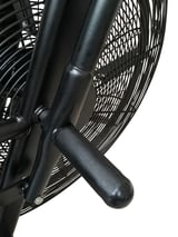 Close-up of black box fan showing metal frame, protective mesh grille, and textured handle grip