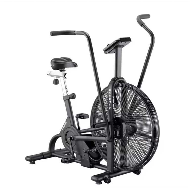 Black stationary exercise bike with large fan wheel and dual handles against white background