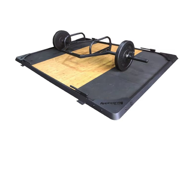 Black wheeled skateboard-like device with tan wooden platform and metal frame on dark mat